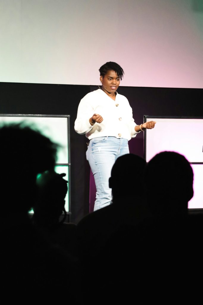 A woman standing on a stage in front of a crowd