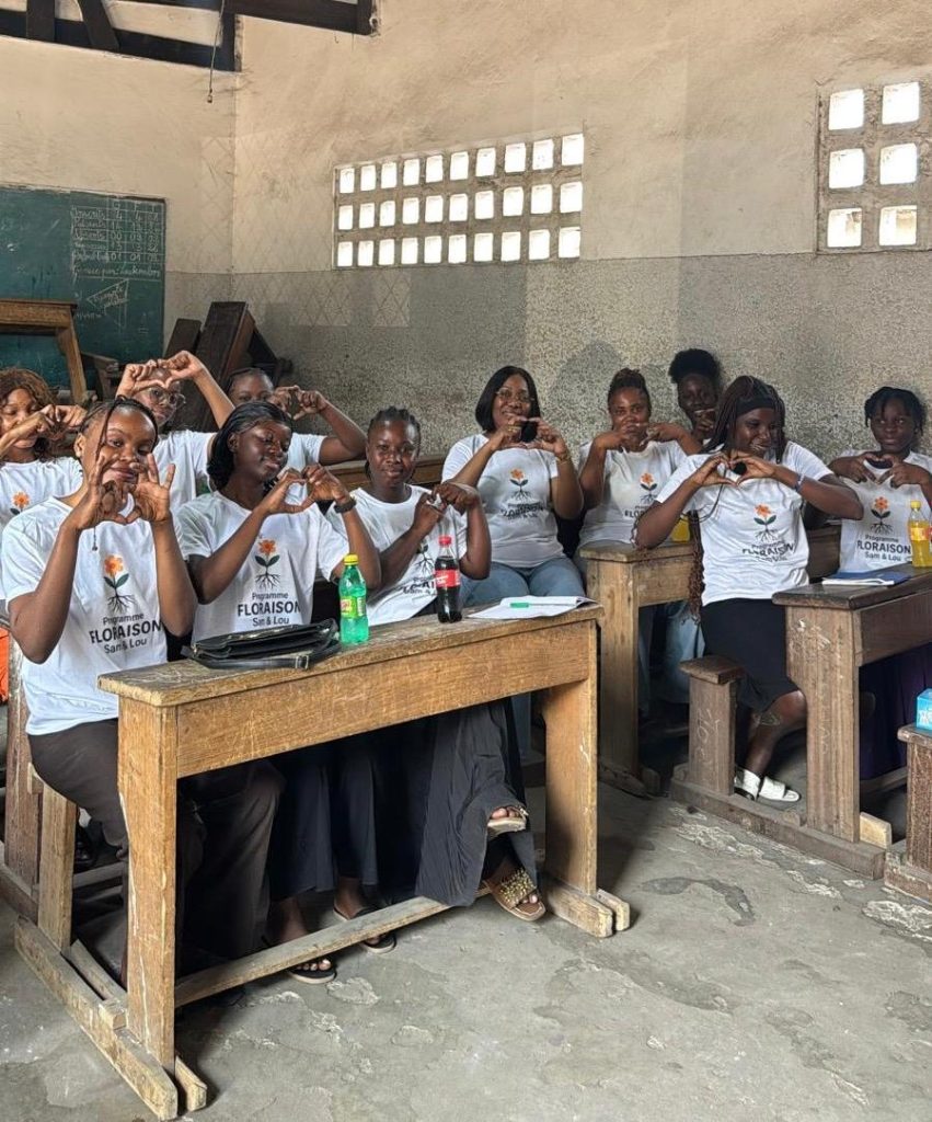 Groupe de femmes participant à une session de formation assises dans une salle de classe communautaire.